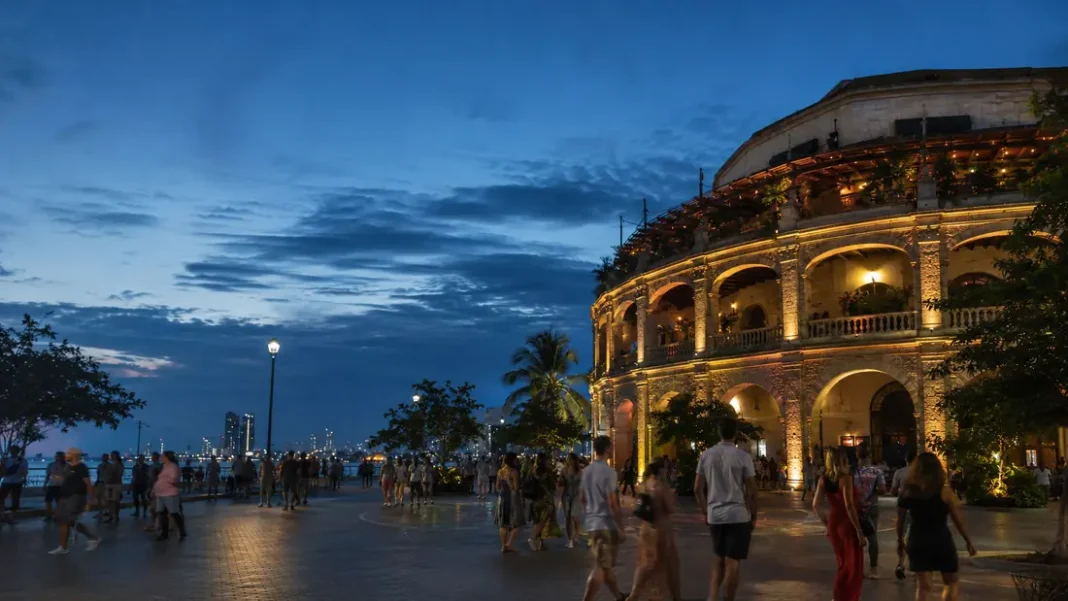 Turistas caminando frente a La Serrezuela en Cartagena al anochecer