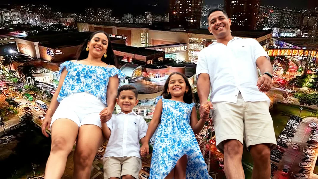 Familia barranquillera camina frente al centro comercial Buenavista y edificios del norte de Barranquilla.