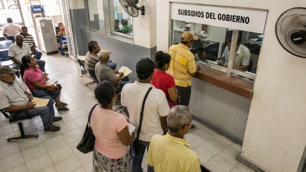 Personas esperando en una oficina pública para recibir información sobre subsidios del Gobierno