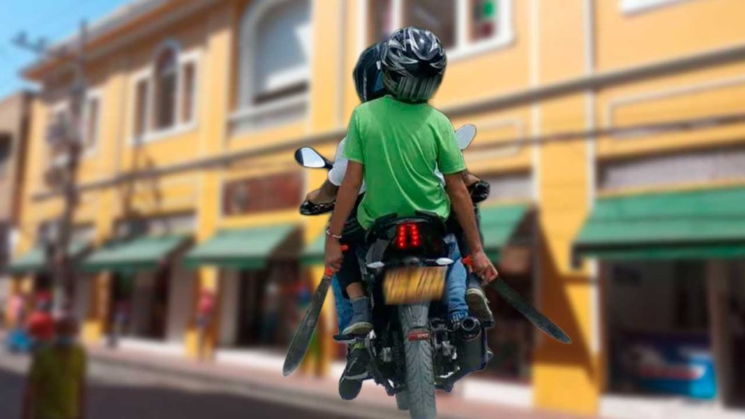 Barranquilla recibe otro plan de seguridad, pero las cifras exigen resultados Comerciante baja la persiana de su tienda mientras una motocicleta con dos ocupantes circula por una calle de barrio.